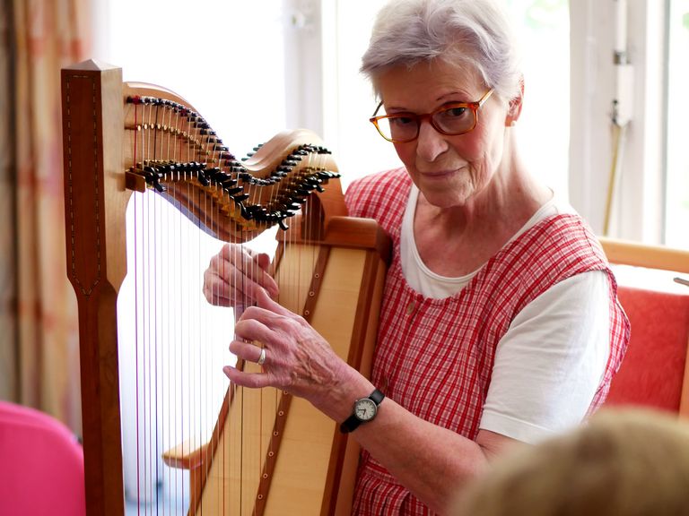 Beschäftigungsangebot im Feierabendhaus - eine Dame spielt Harfe