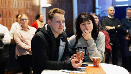 Zwei jüngere Pflegekräfte stehen an einem Tisch mit Bechern in den Händen bei der Weihnachtsfeier 2025 von Amalie Sieveking Krankenhaus, Residenz am Wiesenkamp, Feierabendhaus Volksdorf und Albertinen Kindertagesstätte Volksdorf auf dem Gesundheitscampus Volksdorf in Hamburg