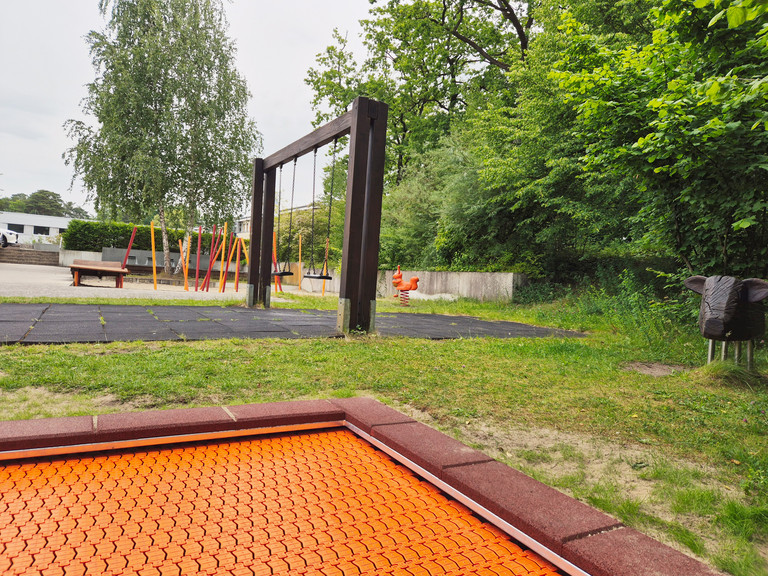 Spielplatz mit Trampolin, Schaukel, Klettergerüst und Wipptier