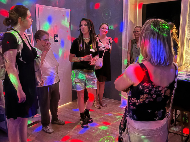Mitarbeiterin stellt Interessenten den neu eröffneten Escape Room vor