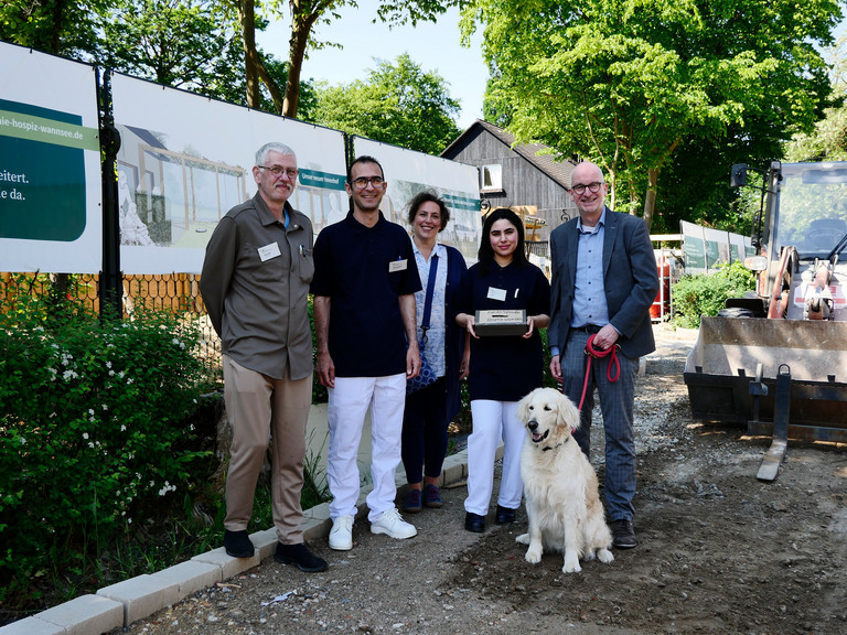 Gruppenfoto: Teamleiter Ralf Damm, Auszubildende Siavash Bagheri und Zahra Albu-Mohammed mit Silvana Schumacher und Hospiz-Geschäftsführer Walther Seiler vor der Baustelle des Hospizes (v.l.n.r.)
